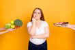 Young woman making choice between healthy and unhealthy food