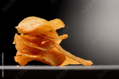 Fotografía Kartoffel Chips gestapelt im Spotlight - vor schwarzem Hintergrund