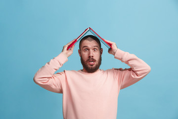 Wall Mural - Businessman holding laptop on head at blue studio