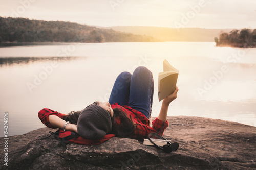 Cuadros en Lienzo Relaxing moment Asian tourist reading a book on rock ,enjoying time on holiday c