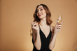 © Drobot Dean - Young happy woman looking away and smiling with champagne