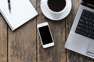 Wall Mural - smart phone blank screen with cup coffee and computer on old wooden table top view.