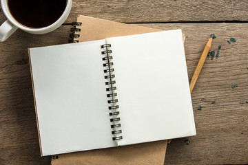 top view of blank notebook with white coffee and natural light on wooden table.