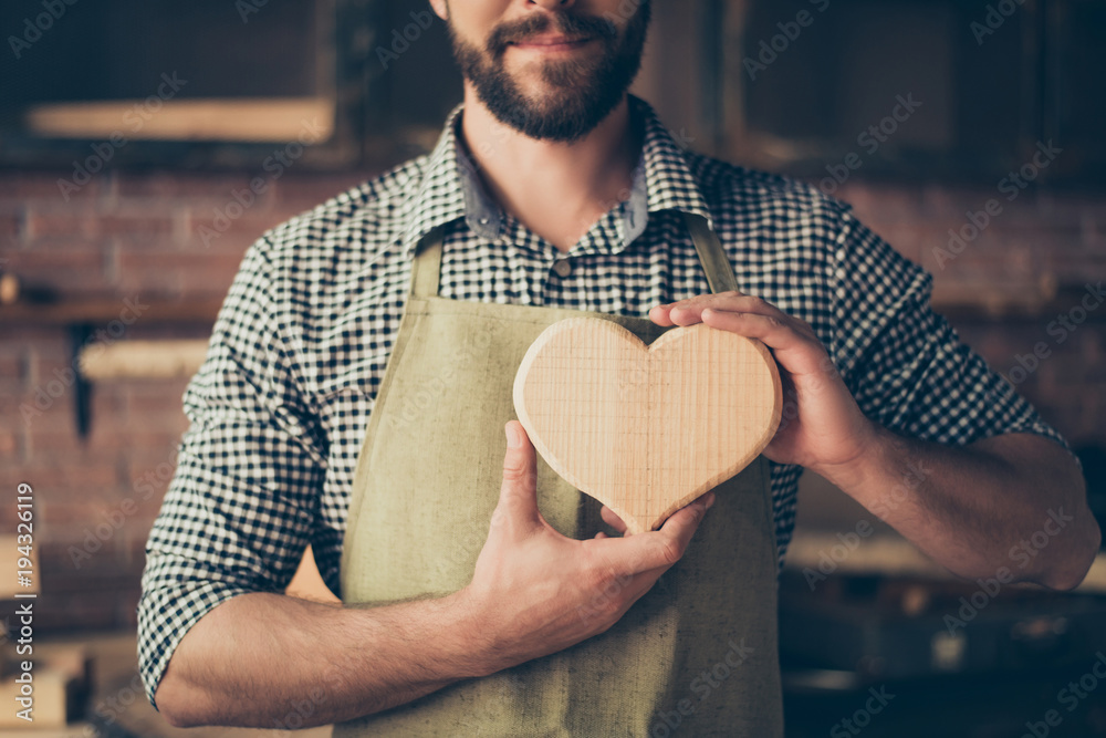 I love my job! Cropped close up photo of happy cheerful joyful carpenter in love, he is showing a heart made of wood - obrazy, fototapety, plakaty 
