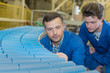 © auremar - engineers looking at rolling conveyor belt in factory