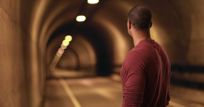 Wall Mural -  - African American stares down a tunnel. A black man looks for a light at the end of the tunnel
