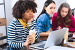 © LIGHTFIELD STUDIOS - selective focus of bored african american young woman with laptop and multicultural students near by