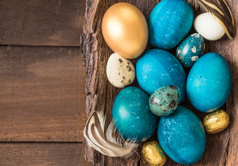 Easter turquoise and gold eggs on wood background text space. Easter holiday card.