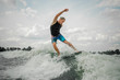 © fesenko - Handsome athletic man wakesurfing on the board against the sky