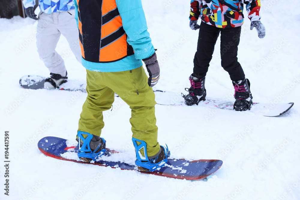 Instructor giving snowboard lessons at snowy resort. Winter vacation