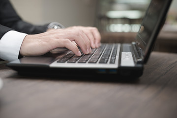 Poster - Young Asian businessman working with a laptop in a coffee shop.