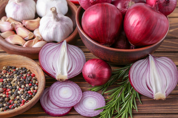 Canvas Print - Bowls with red onion, garlic and spices on table