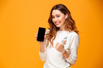 emotional young woman listening music showing mobile phone