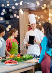 Wall Mural - happy women with chef and tablet pc in kitchen