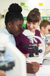 © highwaystarz - Group Of Pupils With Teacher Using Microscopes In Science Class