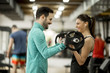© BGStock72 - Young woman with personal trainer in gym