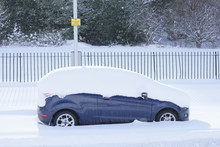 Blue Car Stuck In Deep White Snow Covered On Roof