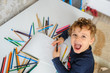 © Med Photo Studio - little boy paints greeting card with colour pencils and smile