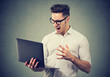 © Feodora - Angry young man watching laptop in rage
