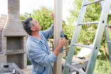 Senior Male Carpenter Working At Home Construction