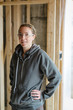 © Rob and Julia Campbell/Stocksy - Portrait of young electrician woman smiling at camera on jobsite