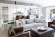 © Trinette Reed/Stocksy - Woman walking through living room of luxury home