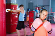 Girl in gloves posing during boxing training at gym