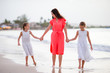 © travnikovstudio - Adorable little girls and young mother on white beach