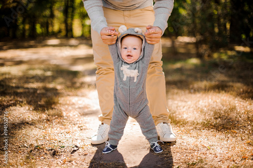 Fototapeta Man walking with a cute smiling baby boy in park