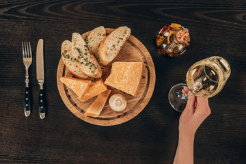 cropped image of woman holding glass of wine at table