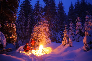 Two tourists are warming up at the fire