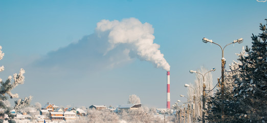 moke from an industrial pipe on a background of blue sky in winter