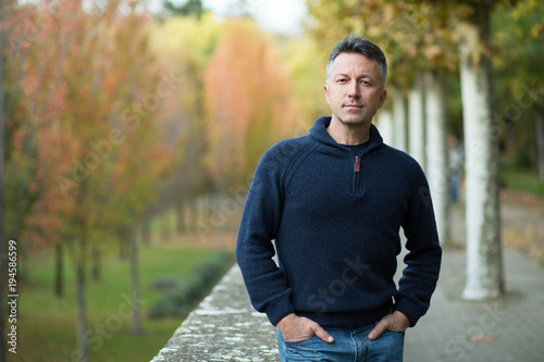 Handsome middle-aged man walking autumn park Tableau sur Toile