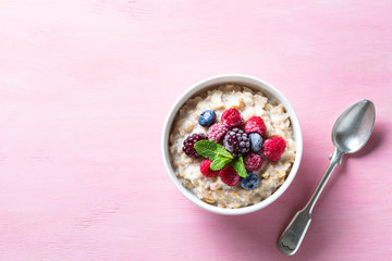 Wall Mural - Oatmeal cereal with milk and berries top view.