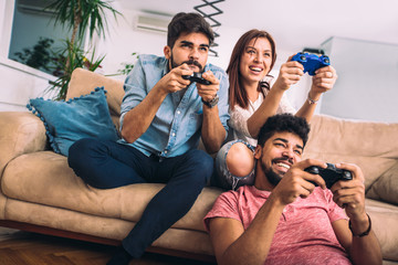 Wall Mural - Group of young friends play video games together at home.