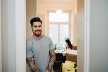 Portrait Of Smiling Man Leaning On Doorway At New Home