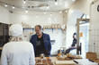 © Maskot - Male customer buying food from owner at bakery