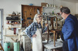 © Maskot - Smiling female owner showing wooden chair to customer at workshop