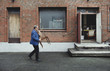 © Maskot - Full length of senior man carrying wooden chair while walking by workshop