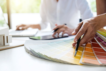 Aufkleber - Two young women interior design or graphic designer working on project of architecture drawing with work tools and color swatches, colour chart in digital tablet at workplace