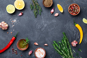 Mixed spices and herbs on black stone table top view. Ingredients for cooking. Food background.