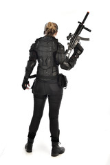 Sticker - full length portrait of female  soldier wearing black  tactical armour, holding a rifle gun, isolated on white studio background.