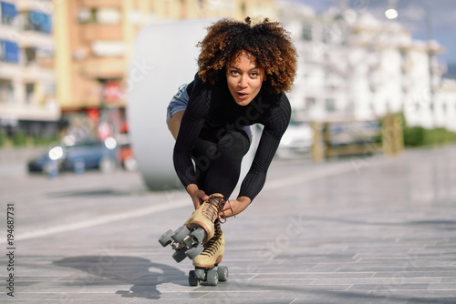 Fotografía Black woman on roller skates riding outdoors on urban street