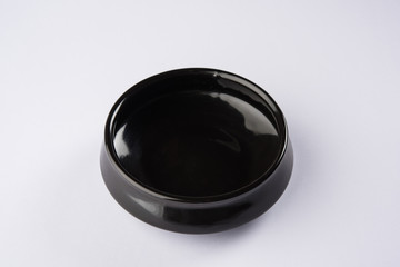 Empty black ceramic serving bowl, isolated over white or gray background
