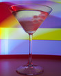 A martini glass with a cocktail in beautiful light of different colors