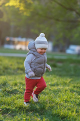 Wall Mural - Toddler child in warm vest jacket outdoors. Baby boy at park.