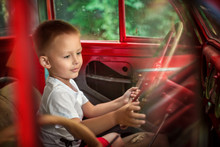 Little Boy Driving Red Old Car