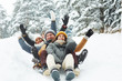 © pressmaster - Four funny friends in winterwear riding down hill in snow on winter weekend