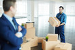 © pressmaster - Young worker of distribution center helping director of business organization load packed boxes during relocation to new office