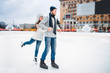 Happy love couple poses on skating rink